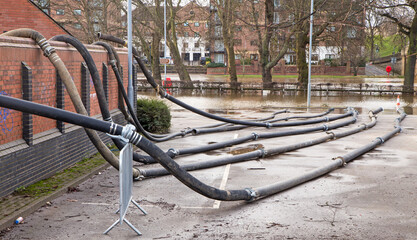 Hose pipes laid out after being used to pump water from flooded buildings