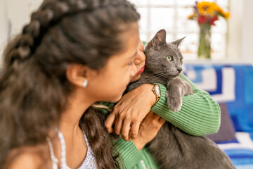 Obraz premium Mother and daughter embracing pet cat at home