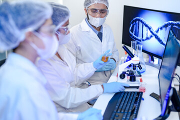 Pharmaceutical research team collaborating on drug development project. Experts in safety gear...