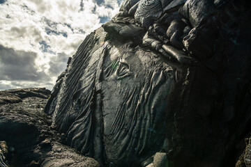 Fototapeta premium Hardened lava field with detailed volcanic textures on the Big Island of Hawaii, formed by ancient lava flows under natural daylight.