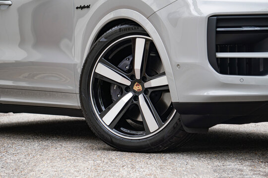 White Porsche Cayenne Coupe front wheel closeup, Luxury performance SUV with silver and black alloy rims on outdoor road
