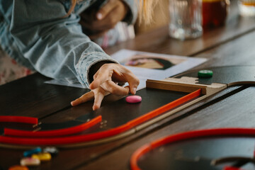 Obraz premium Hand playing tabletop game with colorful pieces