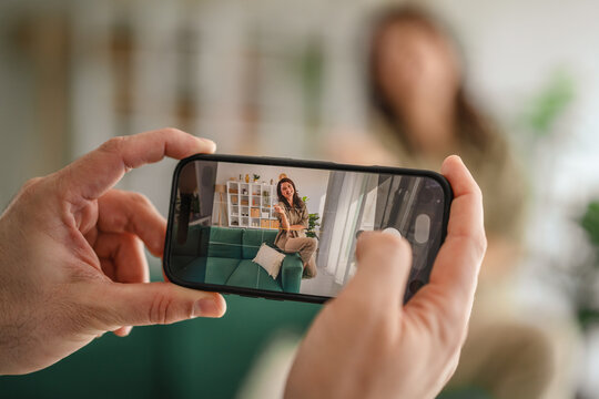 Person recording woman posing for social media content