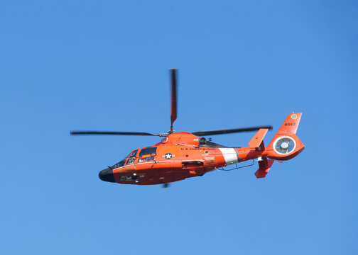 Alameda, CA - Feb 2, 2026: U.S. Coast Guard helicopter in flight on a dark blue sky