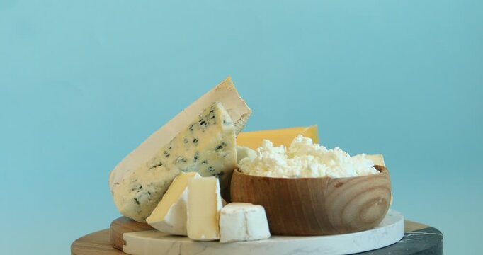 Different dairy products on light blue background, spinning