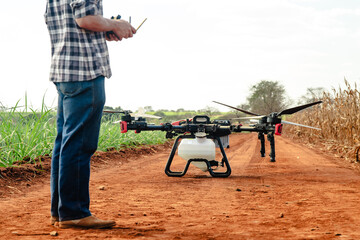 Modern farmer operating a professional agricultural drone for precision farming on a rural dirt road © Nexa