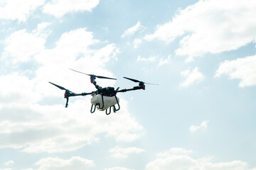 Fototapeta premium Industrial agricultural drone flying in the sky for smart farming and crop dusting