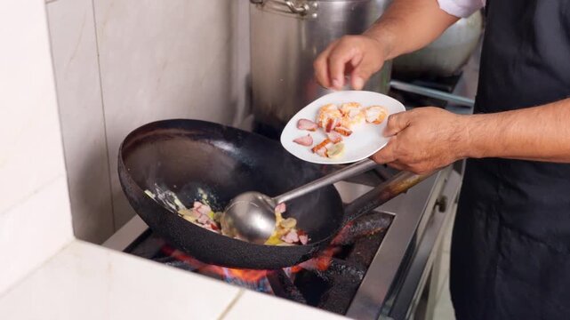 Chef cooking authentic chifa in a wok with fire