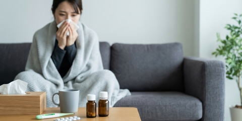 Home woman winter disease health with korean season unhealthy ache allergy asia autumn blanket blowing nose on sofa feeling cold and sick at home under warm cover