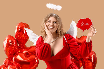 Fototapeta premium Beautiful woman dressed as Cupid holding speech bubble with word LOVE and balloons on beige background. Valentine's Day celebration