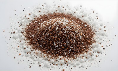 Mound of dark brown soil and white mineral granules are mixed together and scattered on a pure white surface for scientific or gardening material study.