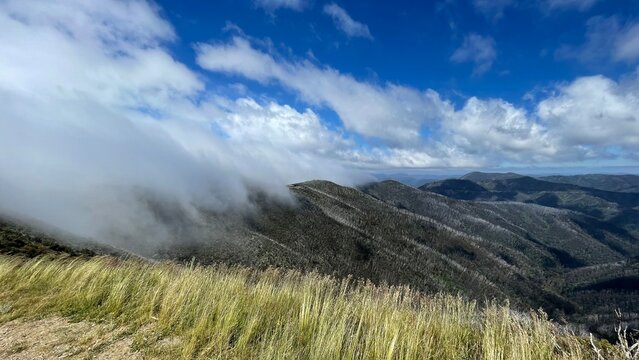 Low clouds rolling over mountain ridgeline in alpine Australia