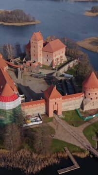 Vertical Screen Trakai Island Castle Traku Pilis In Lithuania Bird Eye Panorama Showing Castle And Island Chain, Sweeping Aerial Reveals Islets, Blue Water And Red Turrets With Expansive