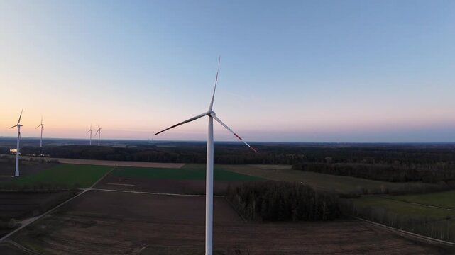 Aerial Centered Turbine Over Cultivated Fields At Dusk, Solitary Tower And Balanced Composition, Pastel Sky With Subtle Glow, Emphasis On Renewable Infrastructure And Calm Rural Setting