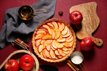 Fototapeta premium Composition with delicious apple pie and ingredients on red grunge background