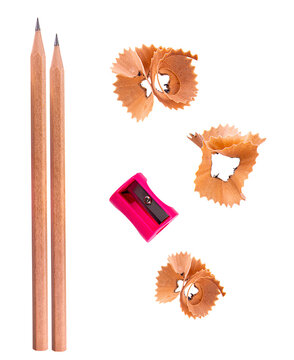 top view of two unsharpened pencils, a pink pencil sharpener, and wood shavings on a transparent background.