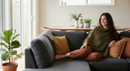 Obraz premium Cheerful Young Woman Relaxing in Cozy Modern Living Room