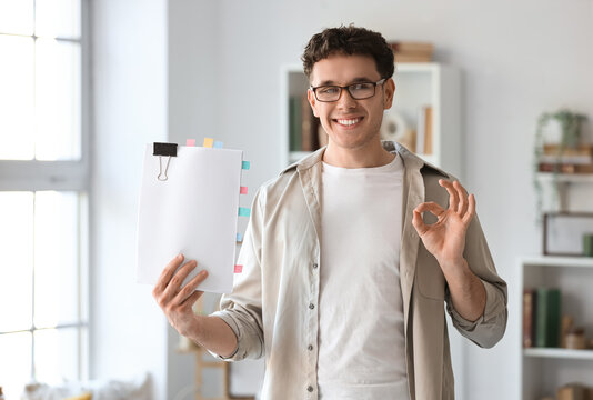 Male screenwriter with script showing OK in office