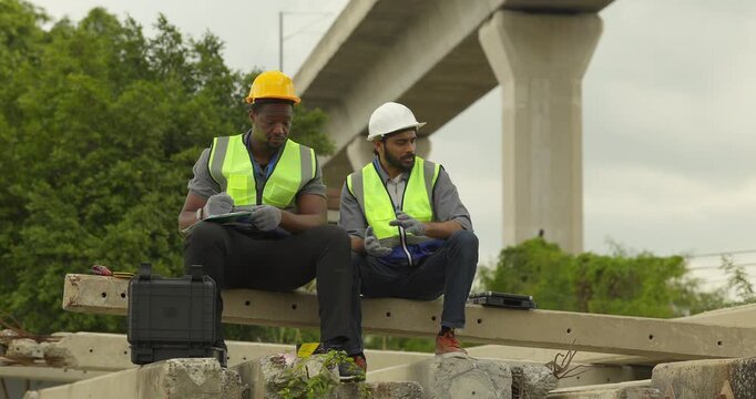 Railway engineer and technician conduct quality control material inspection on concrete pier segments and construction waste. Checking structural condition for safe site housekeeping and asset reuse.
