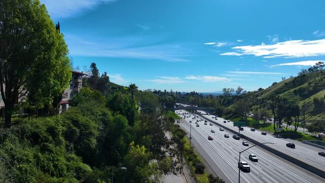 Aerial view ascending in front of traffic on Freeway 101 at Cahuenga Pass in LA