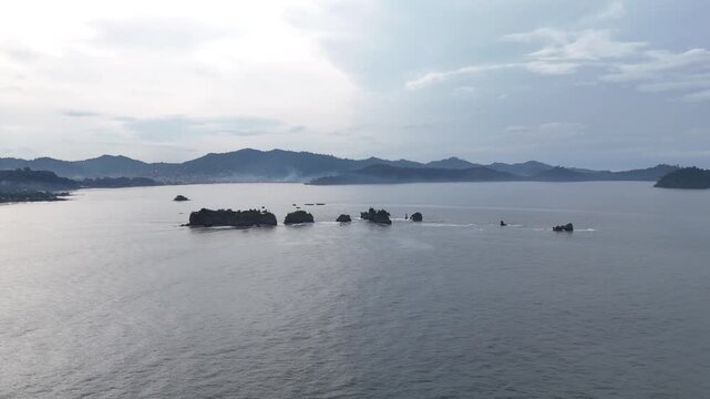 A stunning high-angle perspective of dark volcanic rock formations scattered across the calm Atlantic waters near Limbe Africa Atlantic Ocean aerial drone