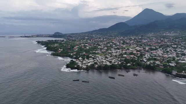 Aerial high-altitude drone panorama looking over the residential buildings and tropical greenery of Limbe, Cameroon