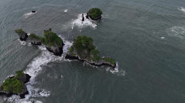 A stunning high-angle perspective of a vibrant green volcanic islet situated in the calm waters of the Atlantic Ocean along the Limbe coast