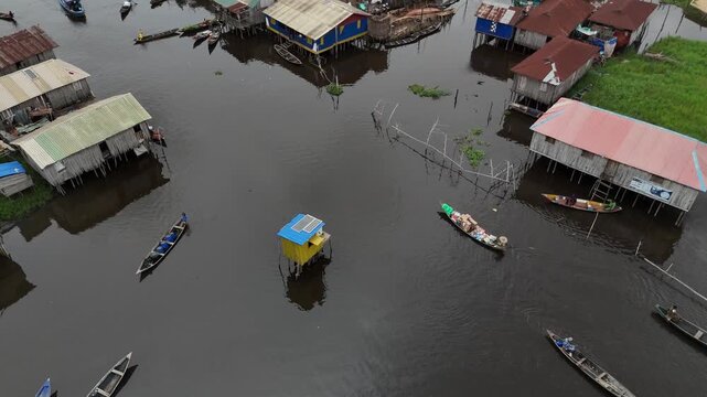 top-down drone perspective of Ganvie Floating Village in Benin West Africa, showcasing the unique layout of houses on water and local residents in wooden canoes