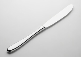 Fototapeta premium A shiny silver butter knife on a gray surface