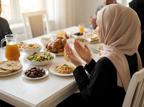 A Muslim family is praying fervently to God, before breaking the fast during the holy month of Ramadan. Capturing a moment of collective devotion, culture