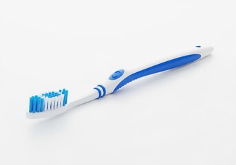 A blue and white toothbrush on a white surface