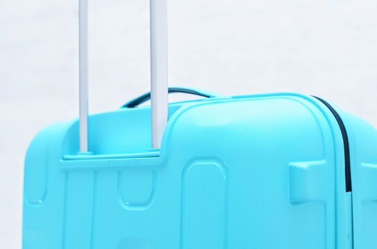 Close up of cyan hard shell suitcase handle and zipper