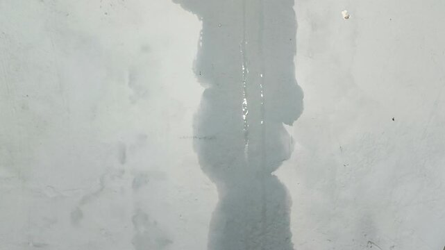Water flowing from above onto the wall due to a leak in the roof. Home maintenance and renovation concepts