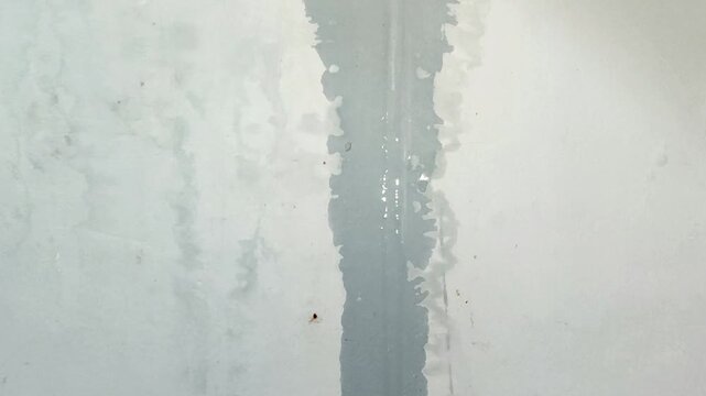 Water flowing from above onto the wall due to a leak in the roof. Home maintenance and renovation concepts