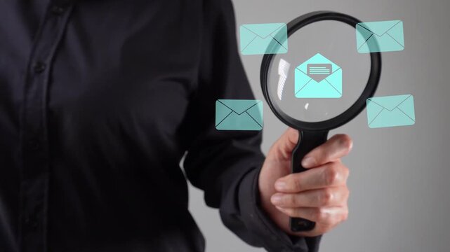 Close-up of a woman's hand with a magnifying glass examining an animation of several closed and one open envelope icons.