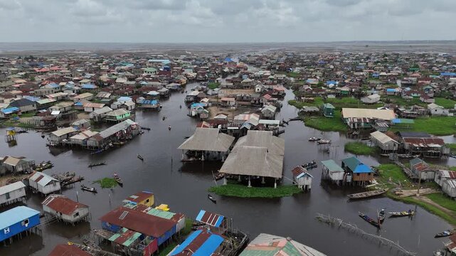 A wide aerial perspective of Ganvie, the largest floating village in Africa, showcasing the dense network of stilt houses and canals