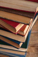 Fototapeta premium Stack of old hardcover books on wooden background, closeup