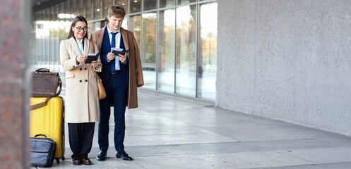 Fototapeta premium Young couple with passports, tickets and luggage near airport building