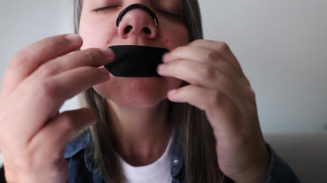 Latina woman using nasal strip and mouth tape for better sleep and breathing - Biohacking and wellness concept