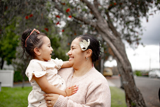 Samoan mum carrying toddler daughter outdoors