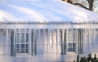 winter house with icicle and snow on the roof