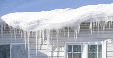 winter house with icicle and snow on the roof