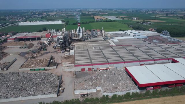 drone view of an integrated cement manufacturing plant showing rotary kiln line, preheater tower, clinker cooling system, raw material storage yards and heavy industrial processing infrastructure.