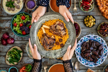 Iftar, break the fasting at holy Ramadan with family, top view of a dining table at iftar time when many human hands sharing their meal. 
