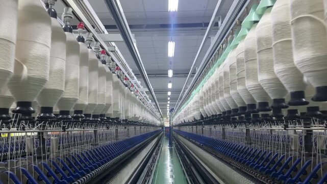 Wide symmetrical view of modern spinning mill producing cotton yarn in large textile factory
