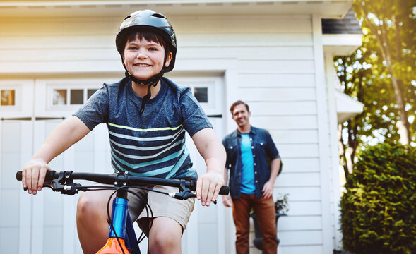 Learning, bike and love with father and son outdoor for riding safety, support or happy. Bonding, cycling lesson and growth with man and kid in driveway of family home for child development and trust
