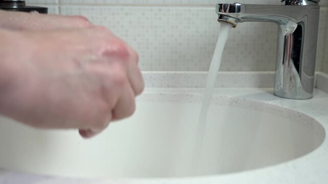 Careful handwashing routine in a clean bathroom, highlighting personal hygiene and the importance of using soap and water to prevent the spread of germs and stay healthy and safe