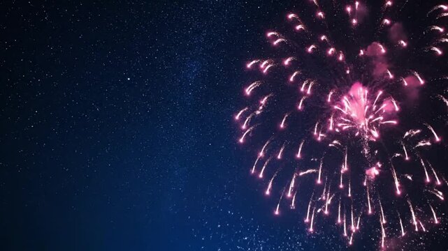 A single pink firework explodes in a starry night sky, leaving a trail of light and smoke.