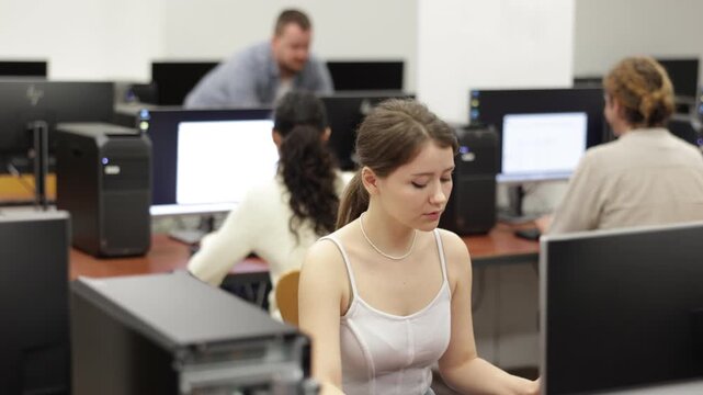 Portrait of female student at computers in university computer class 