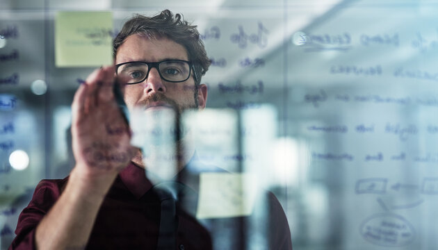 Glass wall, planning and sticky notes with business man in office for brainstorming or strategy. Creative, storyboard and window with design employee in workplace for agenda, schedule or workflow